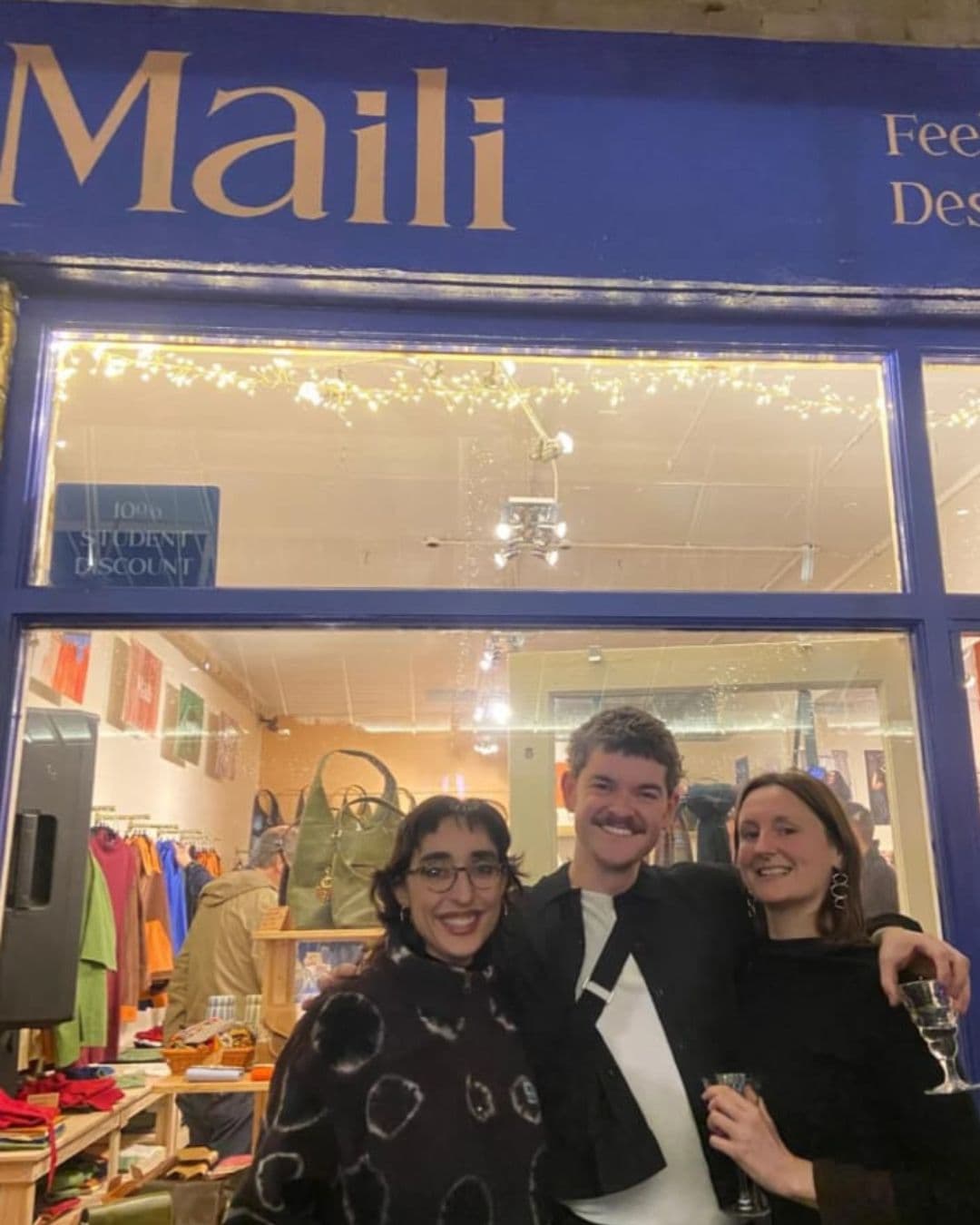 Friends gathered outside the lit-up shopfront on Maili's opening night
