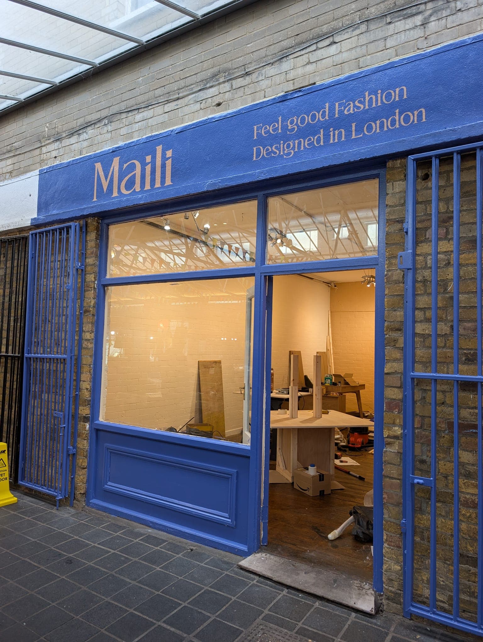 The empty Greenwich Market shop mid fit-out, with the blue Maili signage freshly painted